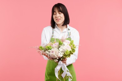 Photo of Florist with beautiful bouquet of flowers on pink background