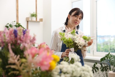 Photo of Florist with beautiful bouquet of flowers indoors