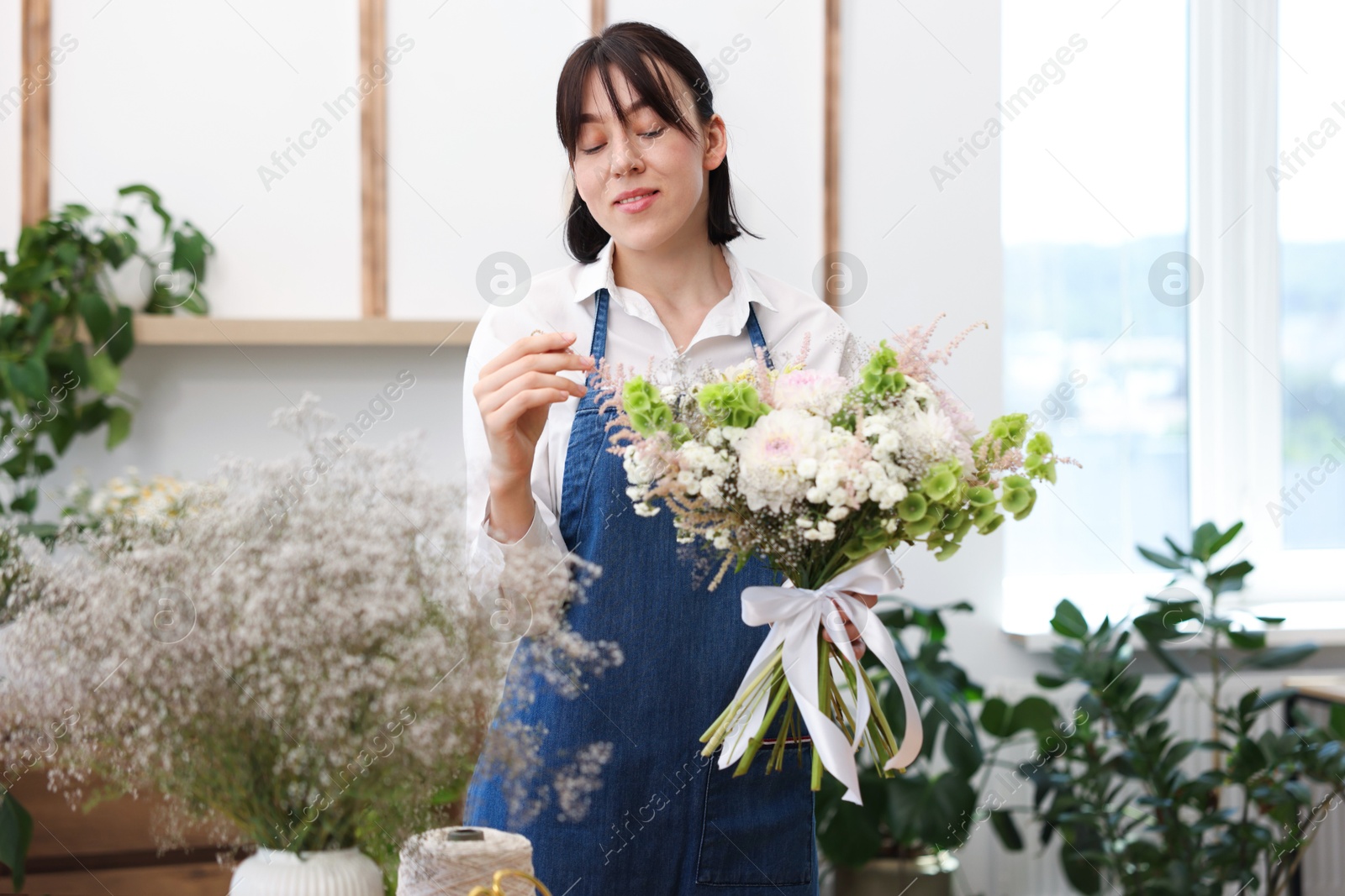 Florist with beautiful bouquet of flowers indoors Photo of Florist with beautiful bouquet of flowers indoors