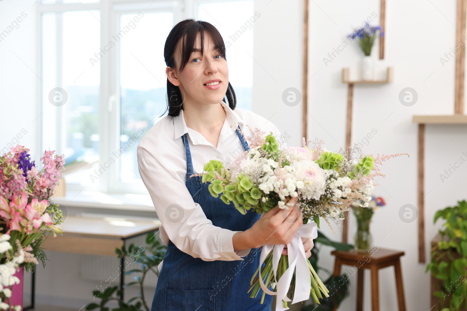Florist with beautiful bouquet of flowers indoors Photo of Florist with beautiful bouquet of flowers indoors