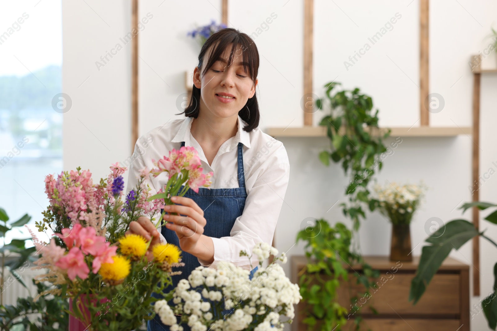 Florist making bouquet of flowers in shop, space for text Photo of Florist making bouquet of flowers in shop, space for text