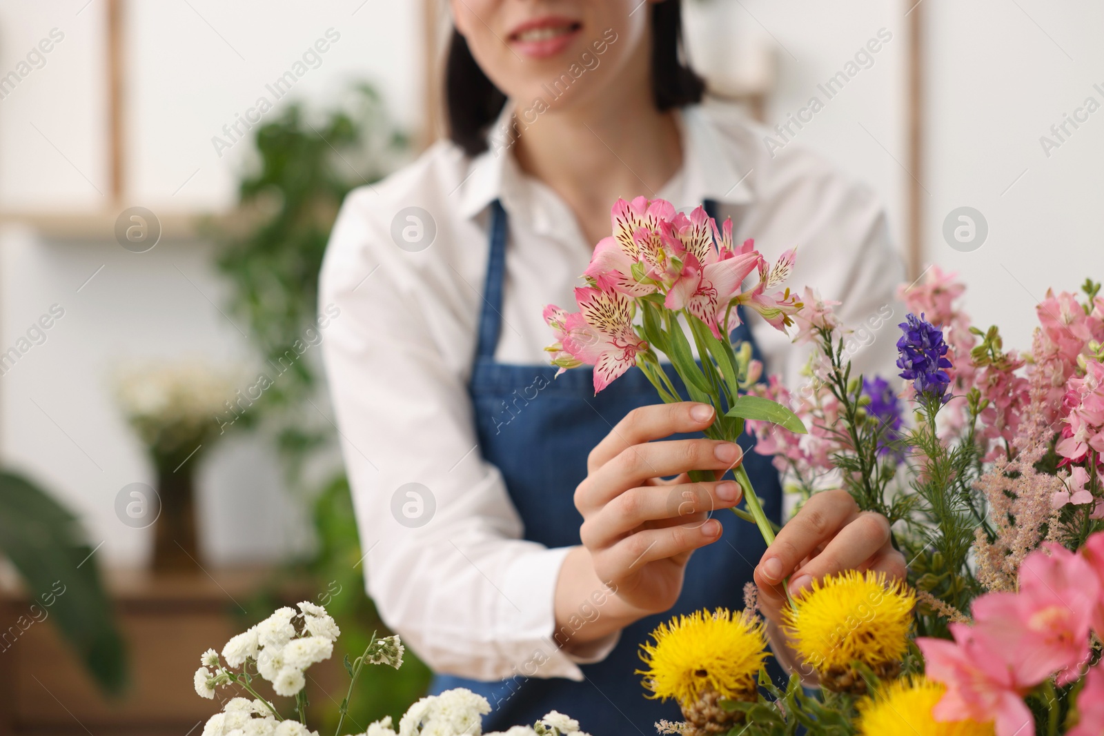 Florist making bouquet of flowers indoors, closeup Photo of Florist making bouquet of flowers indoors, closeup