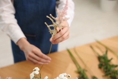 Photo of Florist making bouquet of flowers at table, closeup