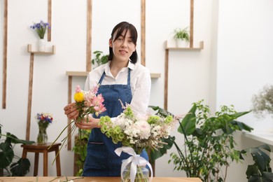 Photo of Florist making bouquet of flowers in shop