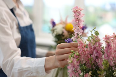 Photo of Florist making bouquet of flowers in shop, closeup