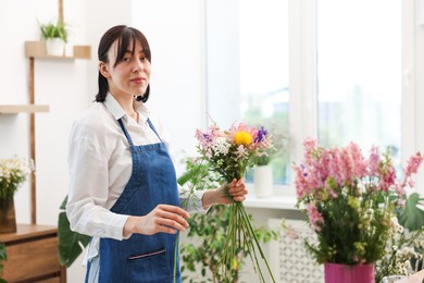 Photo of Florist making bouquet of flowers in shop