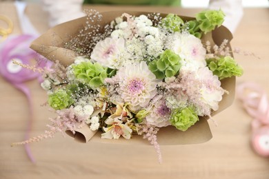 Photo of Florist making bouquet of flowers at table, selective focus