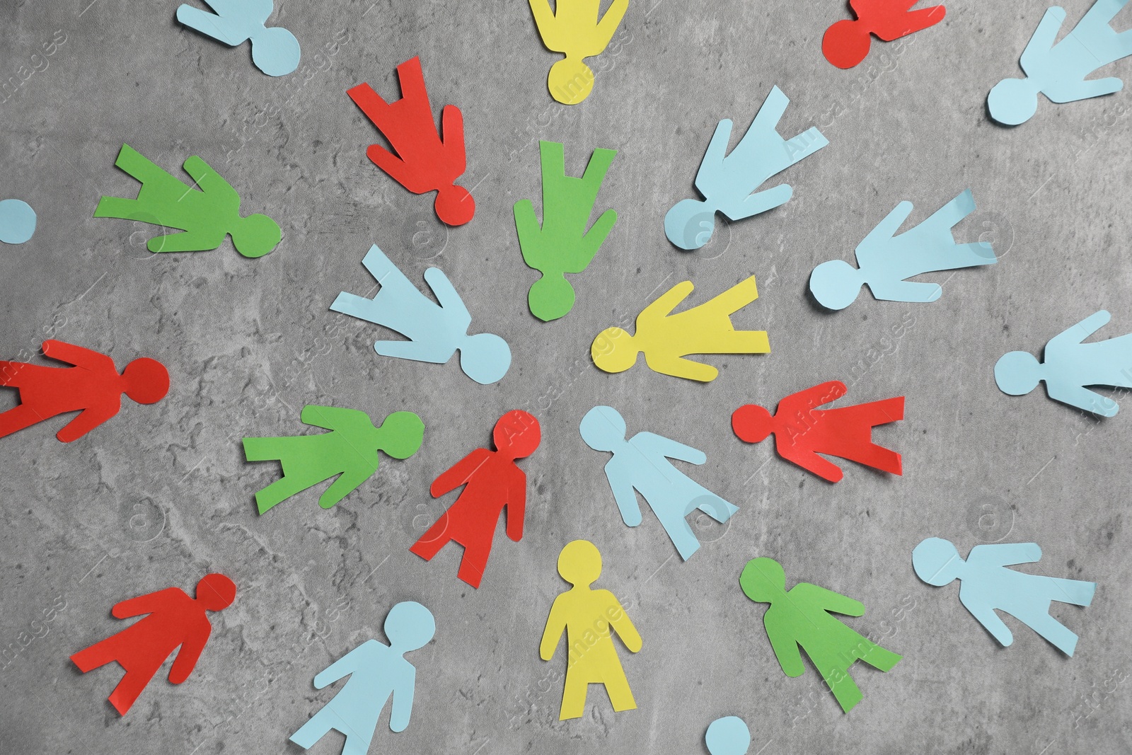 Human paper figures on grey background, flat lay Photo of Human paper figures on grey background, flat lay