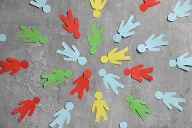 Photo of Human paper figures on grey background, flat lay