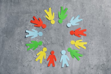 Photo of Human paper figures on grey background, flat lay