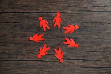 Photo of Human paper figures on wooden background, flat lay