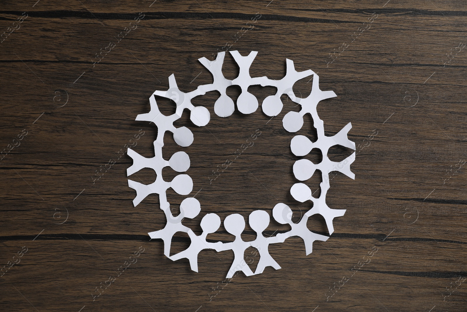 Human paper figures holding hands on wooden background, flat lay Photo of Human paper figures holding hands on wooden background, flat lay