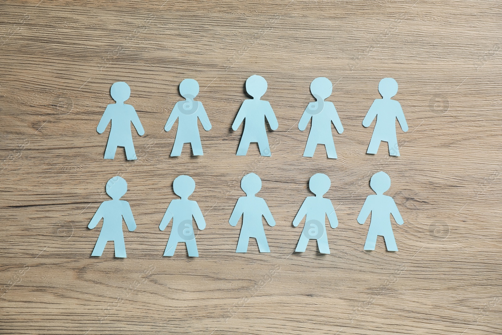 Photo of Human paper figures on wooden background, flat lay