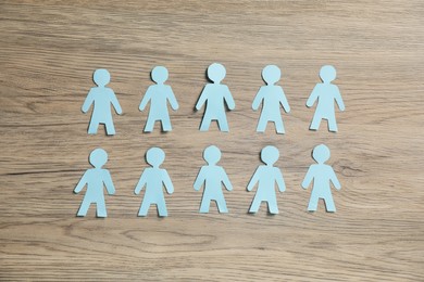 Photo of Human paper figures on wooden background, flat lay