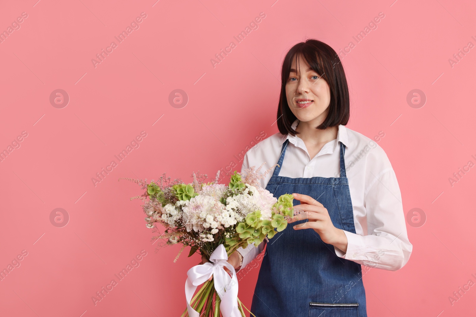 Florist with beautiful bouquet of flowers on pink background, space for text Photo of Florist with beautiful bouquet of flowers on pink background, space for text