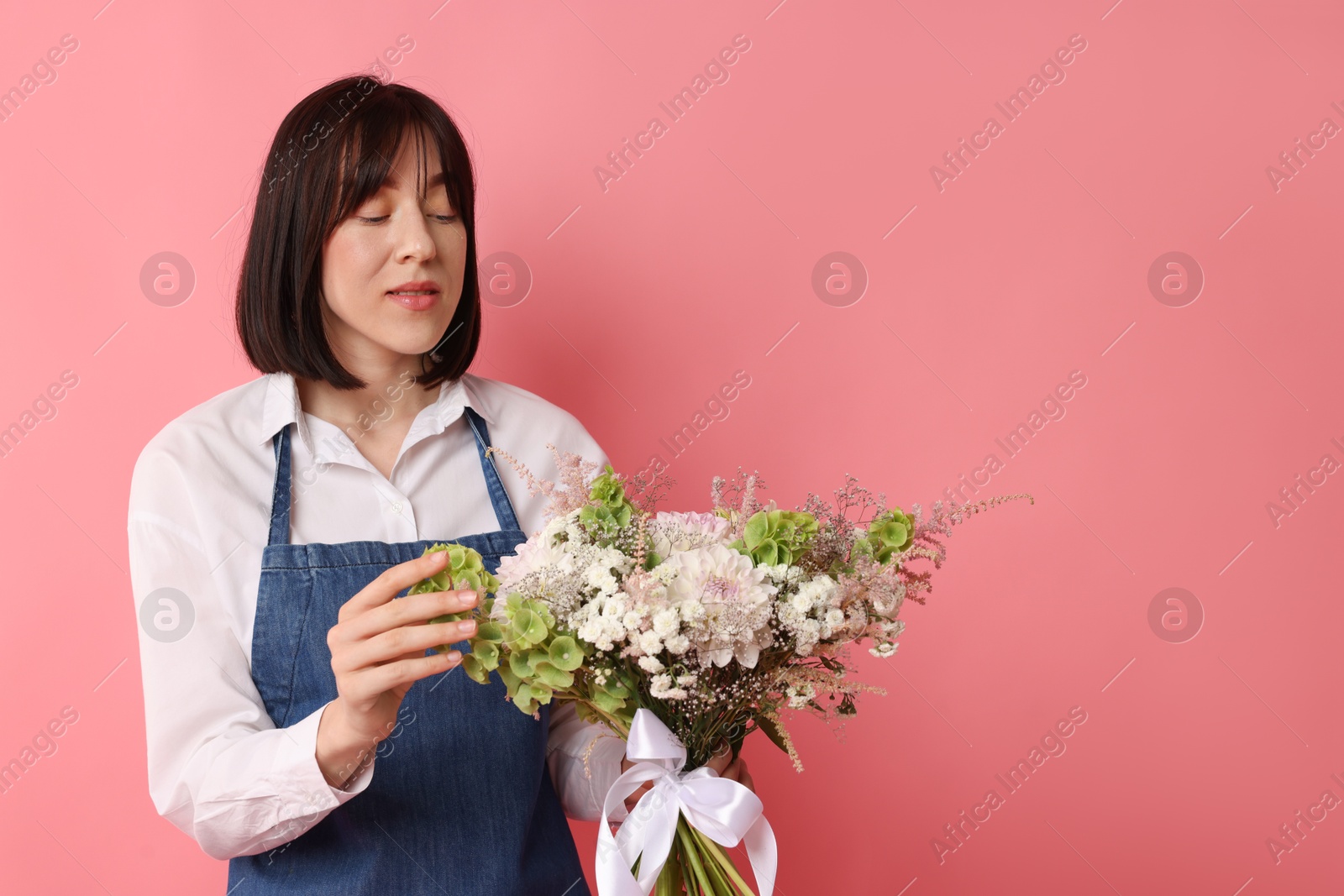 Florist with beautiful bouquet of flowers on pink background, space for text Photo of Florist with beautiful bouquet of flowers on pink background, space for text