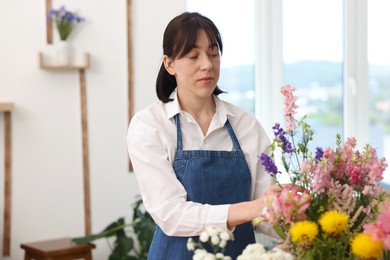 Photo of Florist making bouquet of flowers in shop