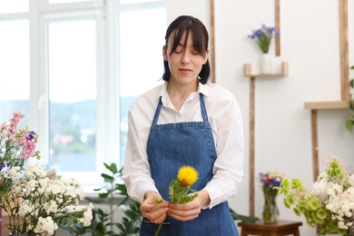 Photo of Florist making bouquet of flowers in shop