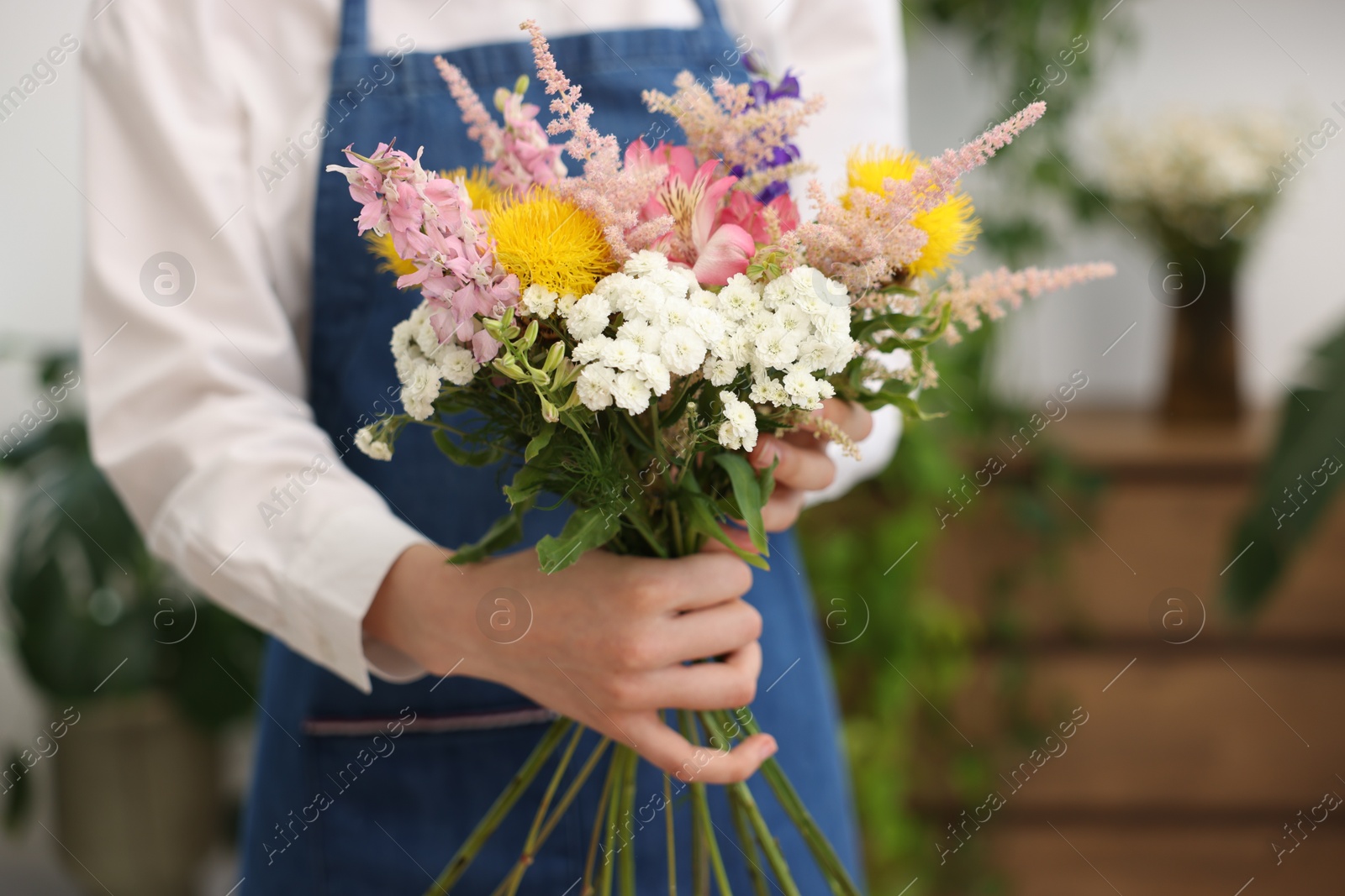 Florist making bouquet of flowers in shop, closeup Photo of Florist making bouquet of flowers in shop, closeup