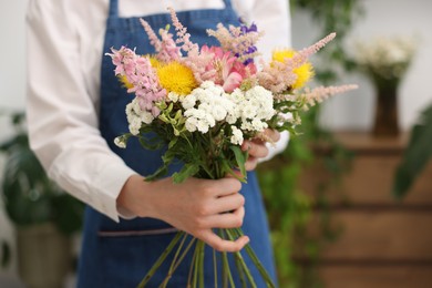Photo of Florist making bouquet of flowers in shop, closeup