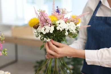 Photo of Florist making bouquet of flowers in shop, closeup