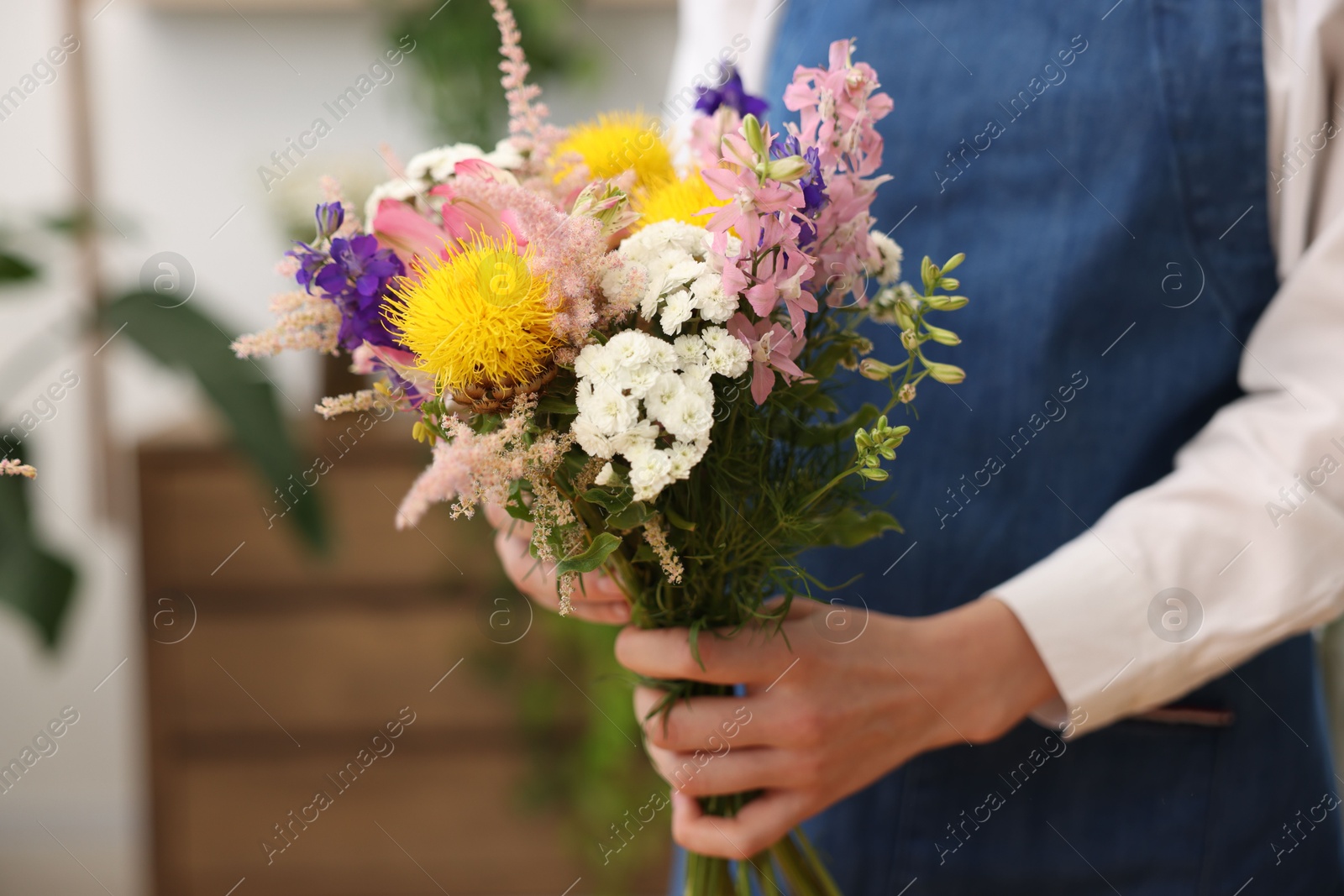 Florist with beautiful bouquet of flowers indoors, closeup Photo of Florist with beautiful bouquet of flowers indoors, closeup