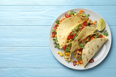 Photo of Tasty vegetarian tacos with chickpeas, corn and quinoa served on light blue wooden table, top view. Space for text