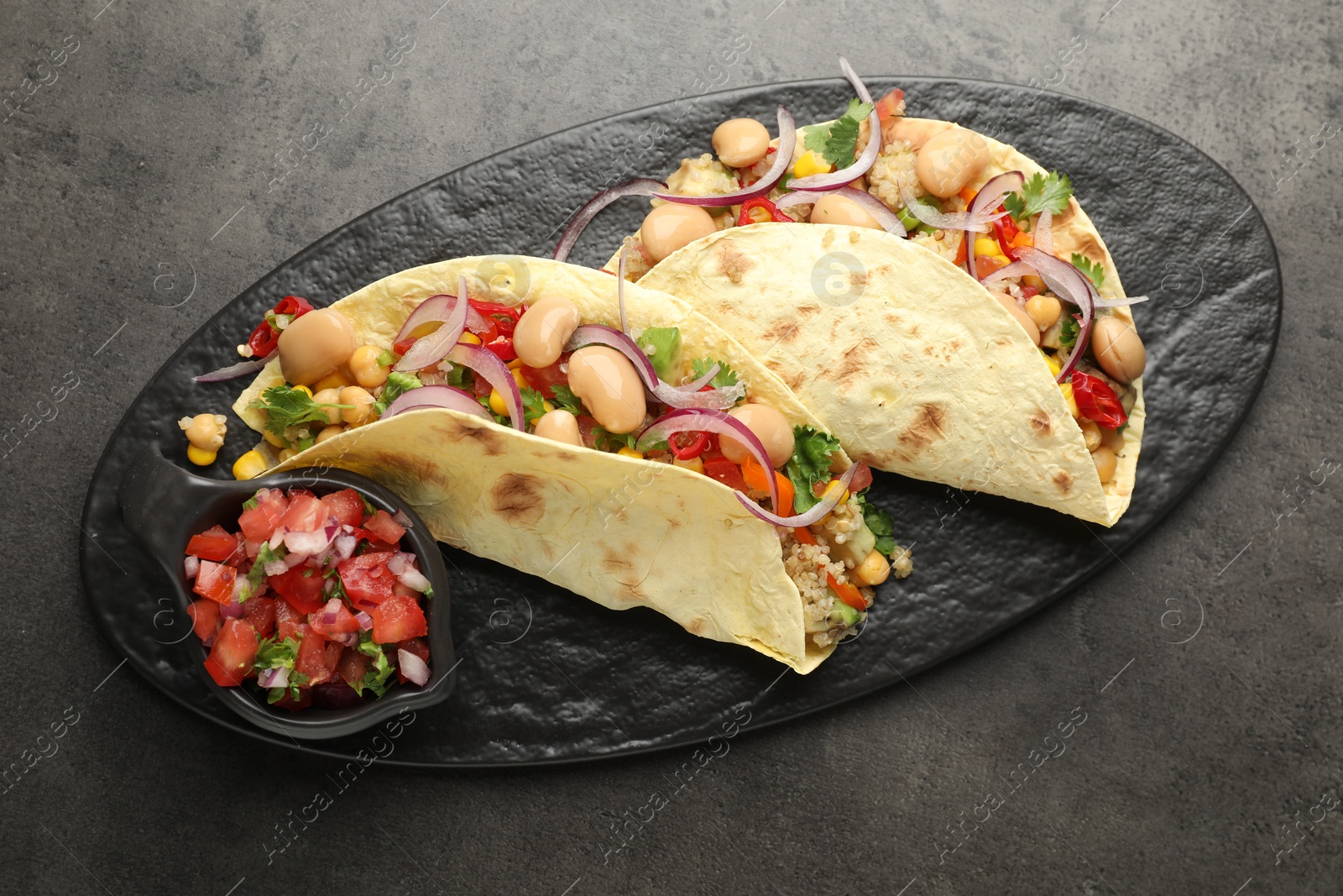 Photo of Tasty vegetarian tacos with beans and quinoa served on grey table, top view