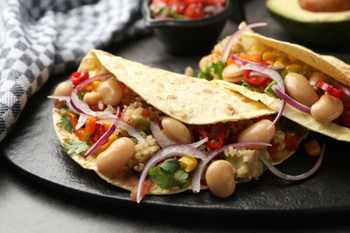 Photo of Tasty vegetarian tacos with beans and quinoa served on grey table, closeup