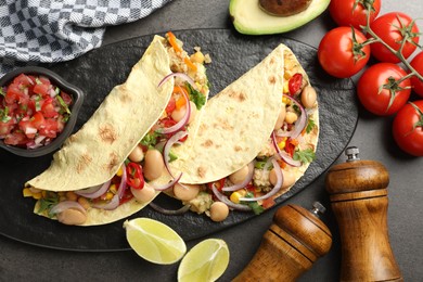 Photo of Tasty vegetarian tacos with beans and quinoa served on grey table, flat lay