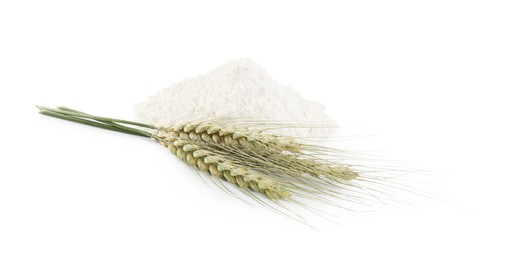 Photo of Pile of flour and green wheat spikes isolated on white