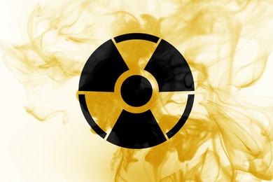 Image of Radioactive sign and yellow toxic smoke against white background