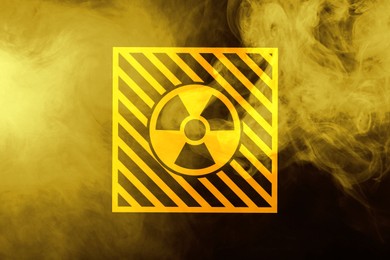 Image of Radioactive sign and yellow toxic smoke against black background
