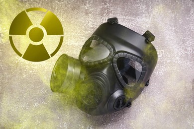 Image of Radiation threat. Gas mask, radioactive sign and smoke on grey background, top view