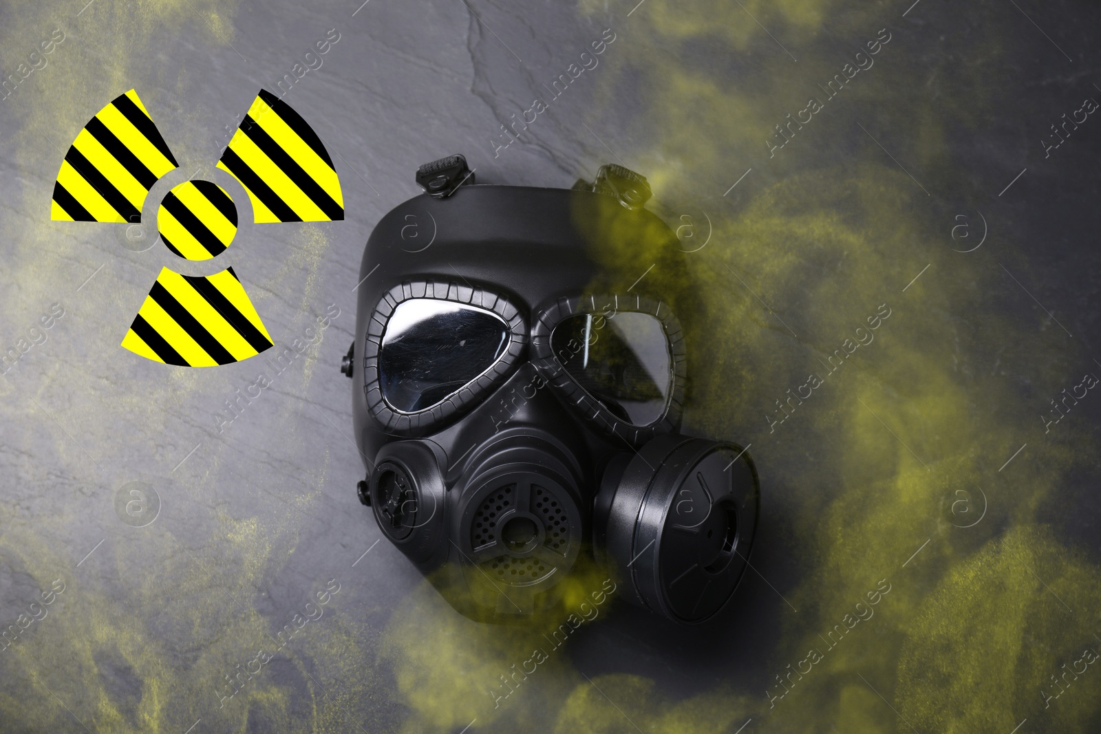 Image of Radiation threat. Gas mask, radioactive sign and smoke on grey background, top view