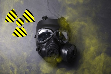 Image of Radiation threat. Gas mask, radioactive sign and smoke on grey background, top view