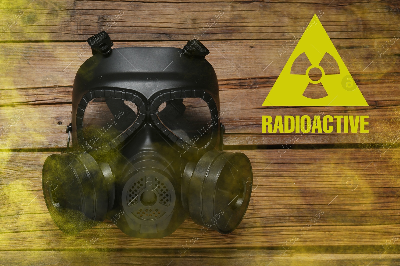 Radiation threat. Gas mask, radioactive sign and smoke on wooden table, top view Image of Radiation threat. Gas mask, radioactive sign and smoke on wooden table, top view