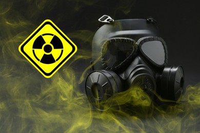 Image of Radiation threat. Gas mask, radioactive sign and smoke on grey table
