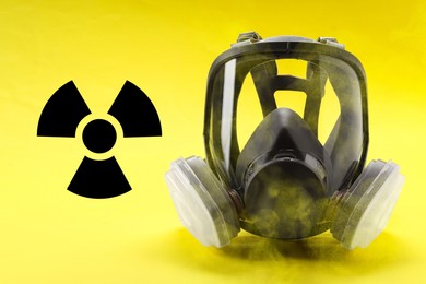 Image of Radiation threat. Gas mask, radioactive sign and smoke on yellow background