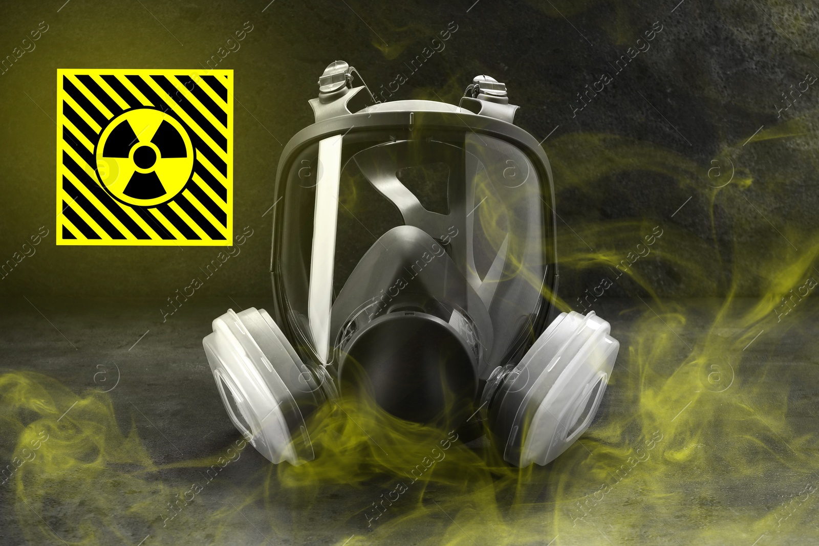 Image of Radiation threat. Gas mask, radioactive sign and smoke on grey table