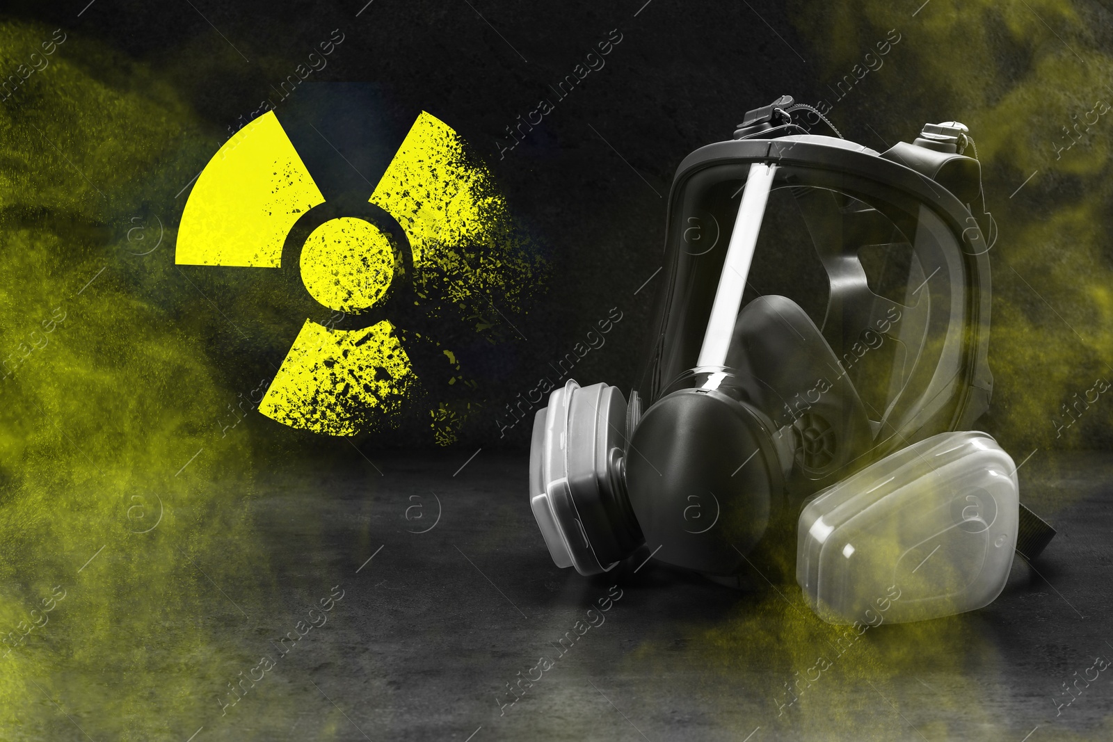 Image of Radiation threat. Gas mask, radioactive sign and smoke on grey table