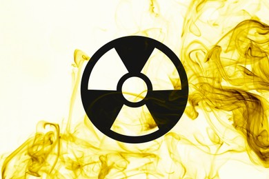 Image of Radioactive sign and yellow toxic smoke against white background