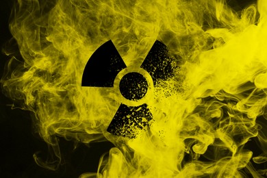 Image of Radioactive sign and yellow toxic smoke against black background