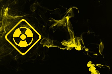 Image of Radioactive sign and yellow toxic smoke against black background