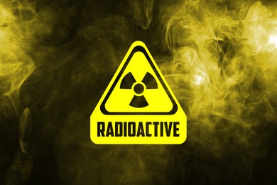 Image of Radioactive sign and yellow toxic smoke against black background