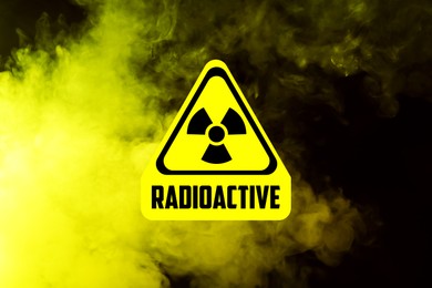 Image of Radioactive sign and yellow toxic smoke against black background