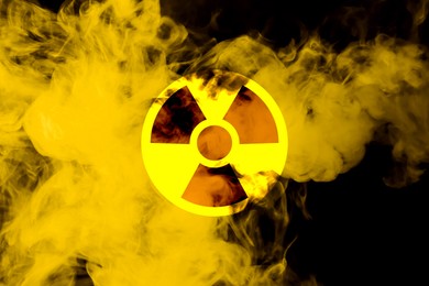 Image of Radioactive sign and yellow toxic smoke against black background