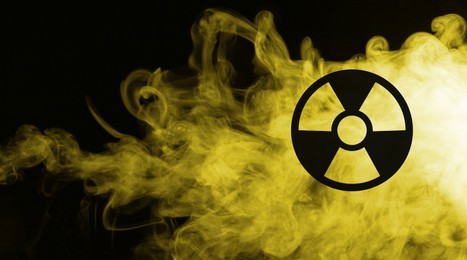 Image of Radioactive sign and yellow toxic smoke against black background. Banner design