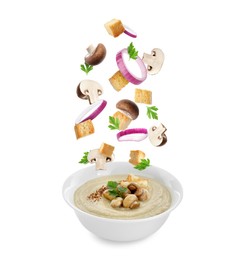 Image of Croutons, onion rings and mushrooms falling into bowl of soup against white background