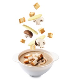 Image of Croutons, mushrooms and potato slices falling into bowl of soup against white background